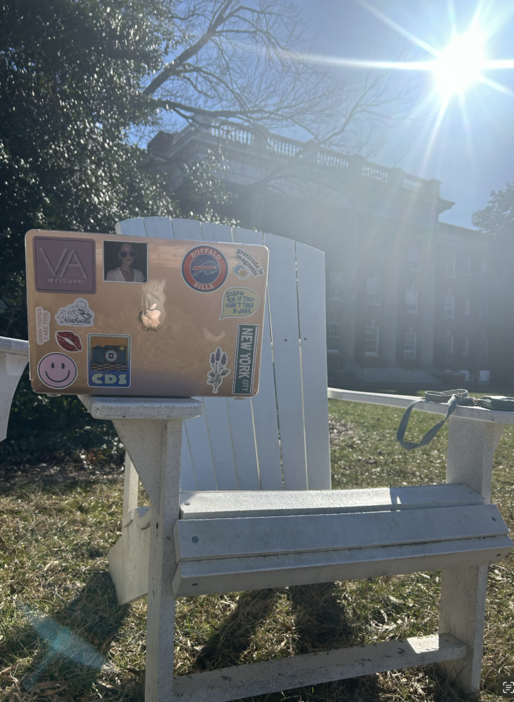 A photo of a chair, with a computer and keys on it outside. 